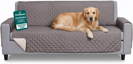 Gray reversible water-resistant sofa cover for pets on a sofa with a dog