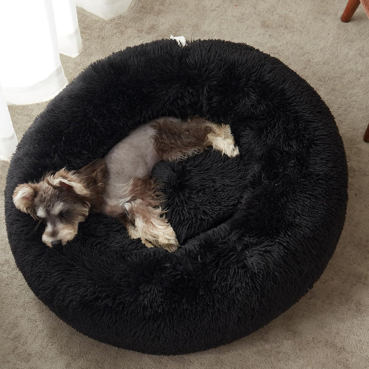 Black faux fur calming donut bed - puppy curled up inside